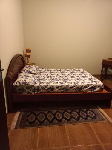 a bedroom with a bed with a floral bedspread at Chácara with pool and trails in the Cerrado biome in São Carlos