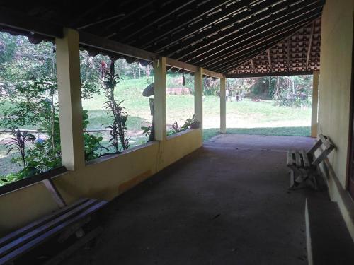an empty room with two benches in a building at Chácara with pool and trails in the Cerrado biome in São Carlos