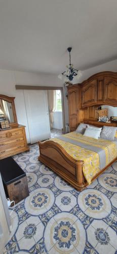 een slaapkamer met een groot bed met een blauw-witte vloer bij Maison d hôtes Salvatrice in Rouvroy