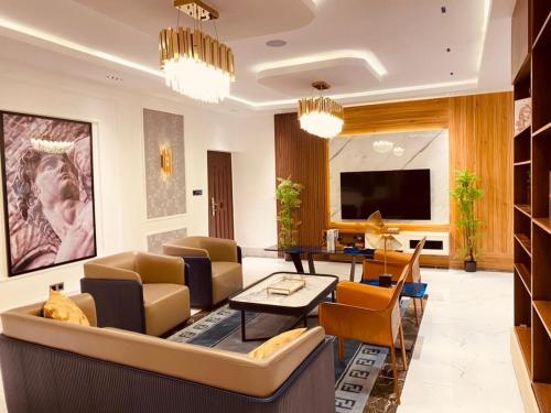 a living room with a couch and chairs and a tv at Sujimoto Shortlet Ave Forche, Banana Island, Ikoyi in Ikoyi