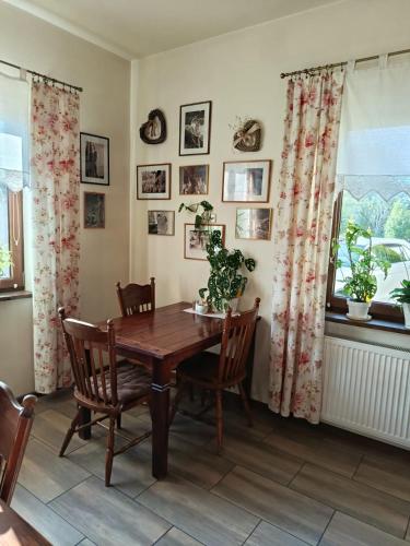 a dining room with a wooden table and chairs at Swojski Klimat in Płońsk