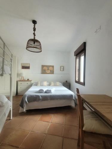 una camera da letto bianca con un letto e un tavolo di El Corral de la Higuera a Campofrío