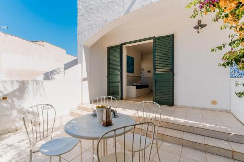 a table and chairs on a patio with a door at Il Rosmarino Casa Vacanze in Taviano