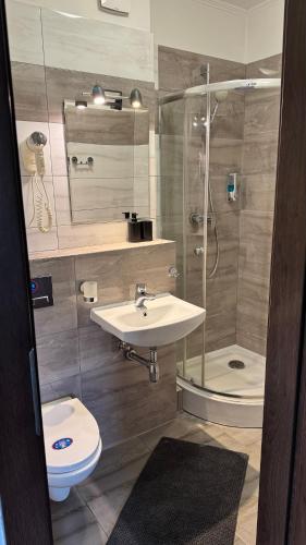 a bathroom with a sink and a shower and a toilet at Hotelik - Modlin Airport in Nowy Dwór Mazowiecki