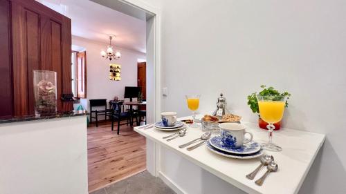 a white kitchen counter with two glasses of orange juice at Family Apartment Heart of Lisbon in Lisbon