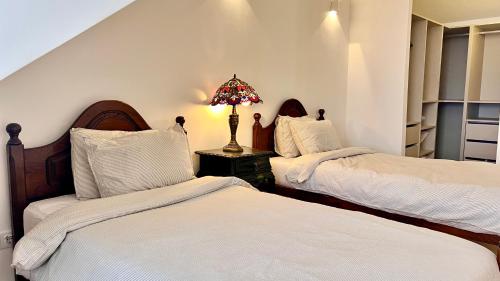 a bedroom with two beds and a lamp on a table at Family Apartment Heart of Lisbon in Lisbon