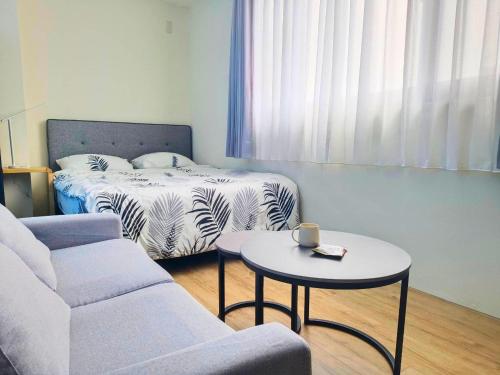 a room with a bed and a table and a couch at 谷園酒店公寓Good Garden Apartment in Taichung