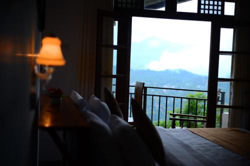 a bedroom with a bed and a view of a balcony at Okeed Ella in Ella