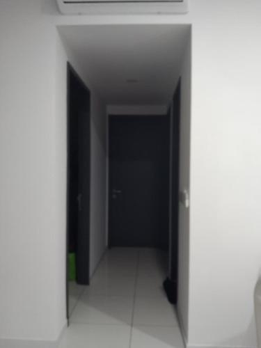 an empty hallway with a black door in a building at The Valley, SkySierra KL in Kuala Lumpur