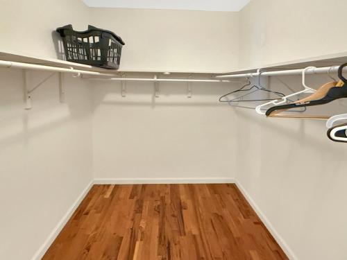 a walk in closet with white walls and wood floors at Homey Townhouse Near Lake & Sports Complex in Guntersville