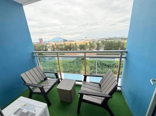 two chairs and a table on a balcony with a view at Cozy and Classy Monaco Suite Mt Arayat View in San Fernando