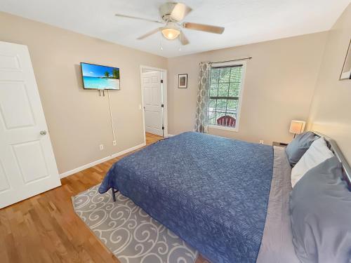 a bedroom with a blue bed and a ceiling fan at Homey Townhouse Near Lake & Sports Complex in Guntersville