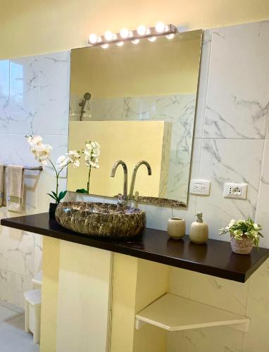 a bathroom with a sink and a large mirror at Villa KAMBUSA appartamento SOFIA in Las Galeras