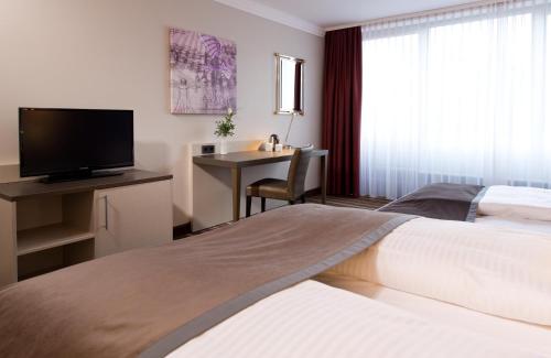 Ένα ή περισσότερα κρεβάτια σε δωμάτιο στο Leonardo Hotel Mönchengladbach