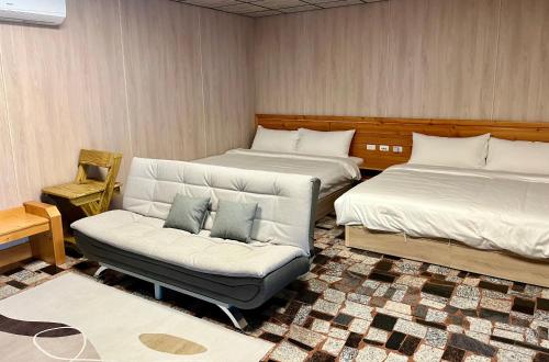 a living room with two beds and a couch at 夏日禾風庭園包棟 in Checheng