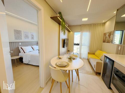 a living room with a table and a room with a bed at Executivo próximo ao Portão, Shopping Palladium e Cidade Industrial in Curitiba