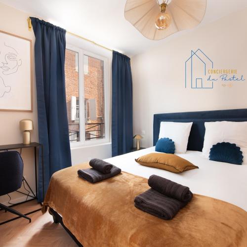 a bedroom with a large bed with two pillows on it at AU XV Sainte Cécile T2 Art Déco in Albi