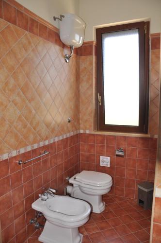 a bathroom with two toilets and a sink and a window at B&B La Terrazza Degli Scrittori in Racalmuto