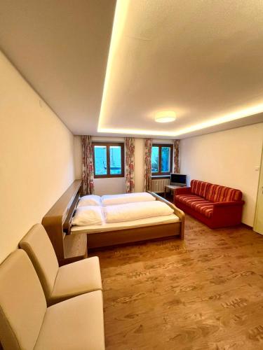 a large room with a bed and a couch at Hotel Goldenes Kreuz - since 1605 in Vipiteno