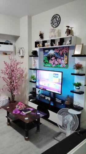 a living room with a table and a computer monitor at Staycation AMAIA SJDM in Tunkong Manga