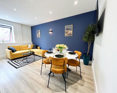 a living room with a table and chairs and a couch at Luxury Norwich City Centre Apartment - Free Parking in Norwich