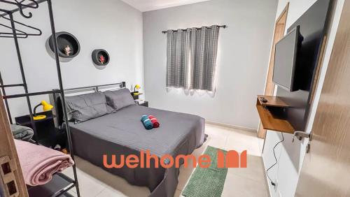 une chambre avec un lit et une télévision à écran plat dans l'établissement Apartamento em São Lourenço bem localizado, à São Lourenço