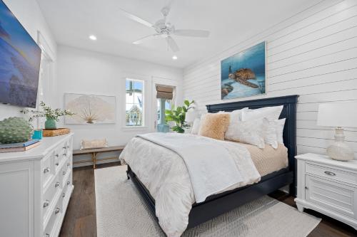 a white bedroom with a bed and a desk at Coastal Charm at Palmilla Beach in Port Aransas