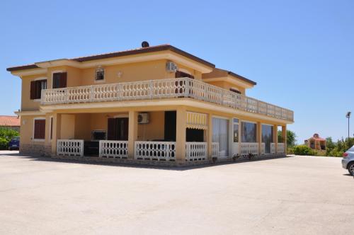 a large yellow house with a balcony at B&B La Terrazza Degli Scrittori in Racalmuto