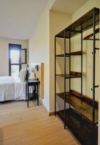 a room with a bed and a book shelf at Hotel Casa Peix in Serraduy