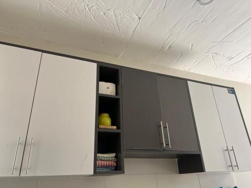 a kitchen with white cabinets and a white ceiling at A cozy spacious studio apartment with a balcony in Nairobi