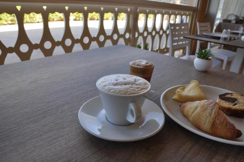a cup of coffee and a plate of bread on a table at B&B La Terrazza Degli Scrittori in Racalmuto