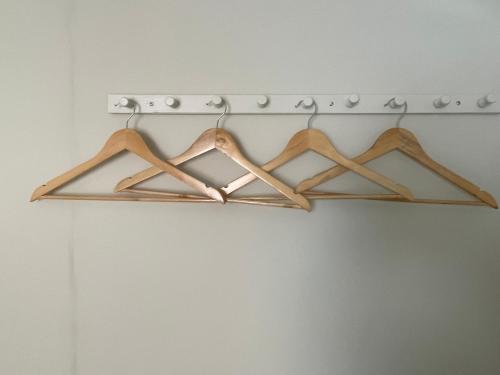 a metal rack with wooden hangers on a wall at 3 Stable Mews in Holsworthy