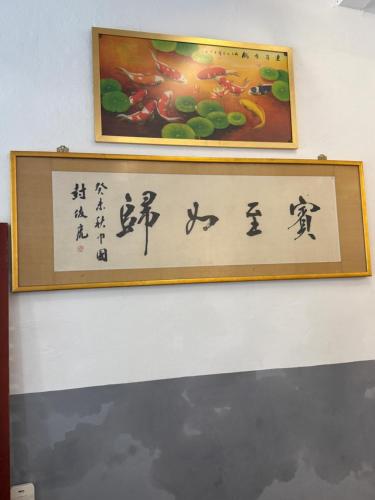 a sign on a wall with chinese writing on it at Heeren Street Boutique Hotel at Jonker Walk in Melaka