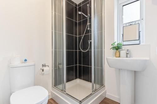 a bathroom with a shower and a toilet and a sink at The Cosy House with Free Parking, Garden and Smart TV with Netflix by Yoko Property - Perfect for Contractors, Groups & Relocation in Leamington Spa