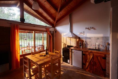 a kitchen with a wooden table and a counter top at Brisa del Bosque in El Bolsón