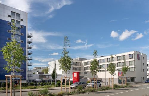 a rendering of an apartment building with cars parked outside at Leonardo Hotel Wolfsburg City Center in Wolfsburg