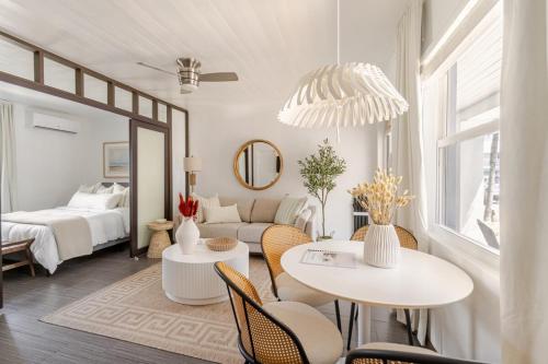 a living room with a bed and a table and chairs at Stylish Coastal Studio Walk to Beach, Pool & Eats in Riviera Beach