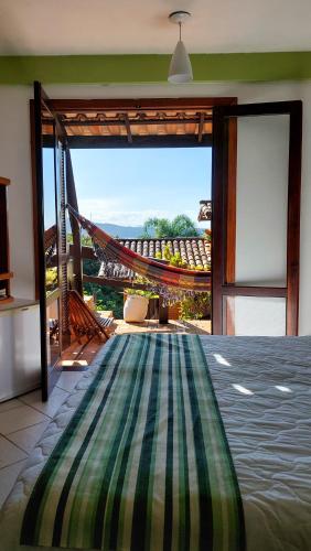 a room with a hammock and a view of the ocean at Pousada Palmeiras Bombinhas in Bombinhas