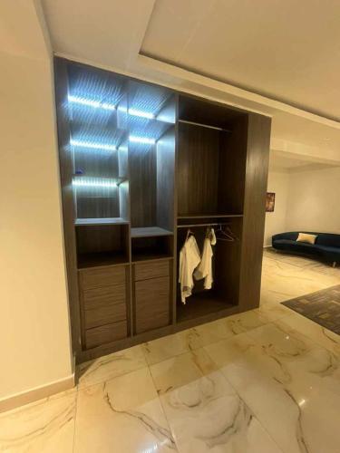 a room with a closet with a robe and a bed at Sujimoto Shortlet Ave Forche, Banana Island, Ikoyi in Ikoyi