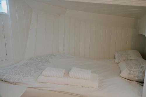 Una cama blanca grande con dos almohadas encima. en City center Amstel river Houseboat Kom en Zie, en Ámsterdam