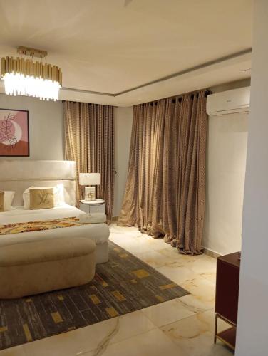 a large bedroom with a bed and curtains at Sujimoto Shortlet Ave Forche, Banana Island, Ikoyi in Ikoyi