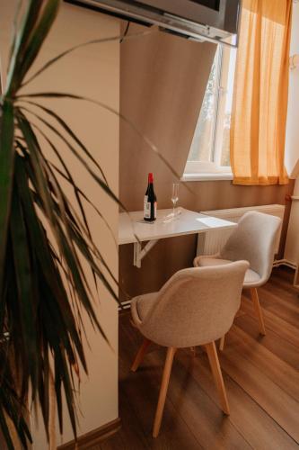 a room with a table and a chair and a bottle of wine at Cathedral park studio in Chişinău