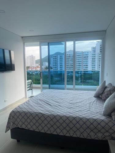 a bedroom with a bed and a large window at Apartamento Santa Marta Reserva del Mar 530 in Gaira