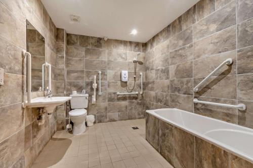 a bathroom with a tub and a toilet and a sink at Magpie Cottage in Newton