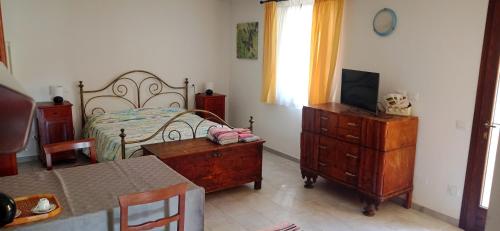 a bedroom with a bed and a dresser and a table at Agriturismo IL CERRO in Marzabotto