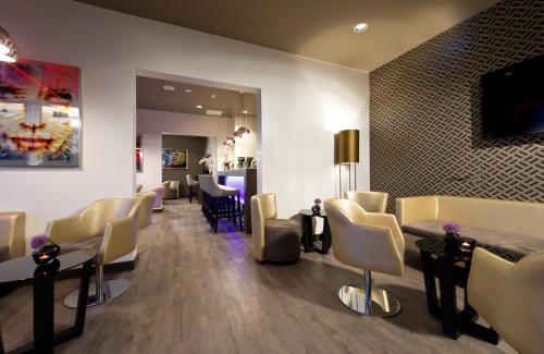 a waiting room with chairs and a hair salon at Leonardo Hotel Munich City Olympiapark in Munich