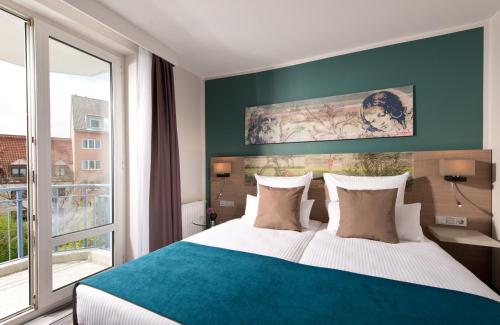 a bedroom with a large bed and a large window at Leonardo Hotel Munich City Olympiapark in Munich