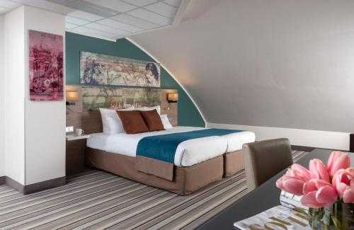 a bedroom with a king sized bed and a desk at Leonardo Hotel Munich City Olympiapark in Munich
