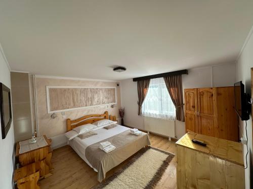 a bedroom with a large bed and a window at Pensiunea Maria in Lacu Rosu