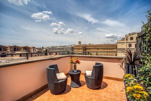 a balcony with three chairs and a table with flowers at Hotel Diocleziano in Rome